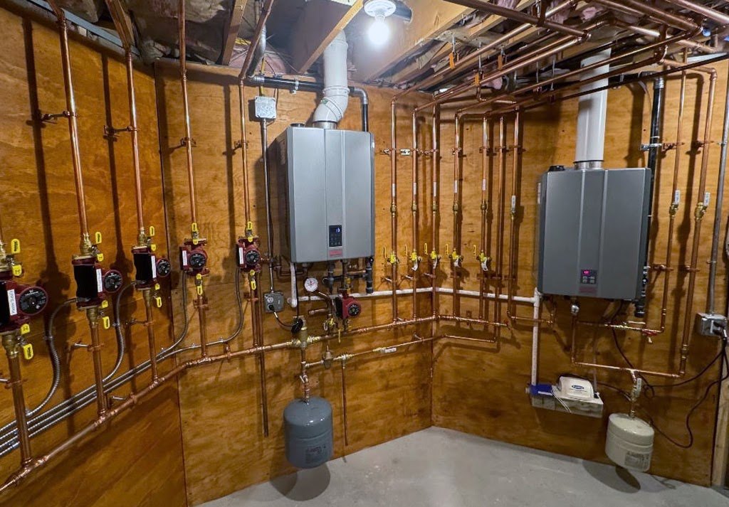 Copper manifold and wall-hung units in a mechanical room, installed by Hometown Plumbing