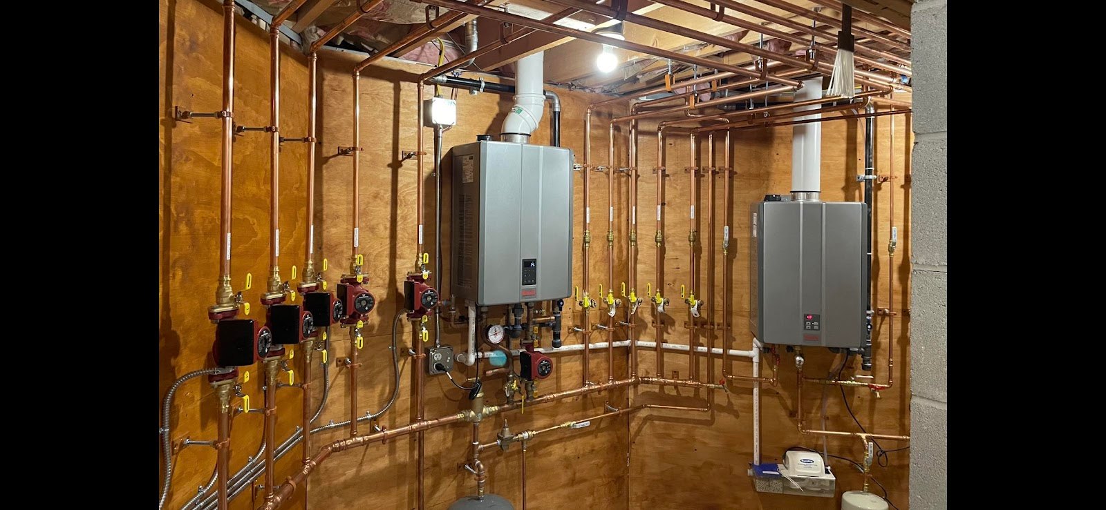 Wall-hung boiler and tankless units with copper manifold installed by Hometown Plumbing